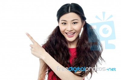 Smiling Chinese Girl Pointing Away Stock Photo