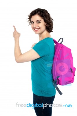 Smiling College Student Pointing Towards The Wall Stock Photo