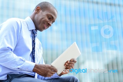 Smiling Corporate Executive Using A Tablet Pc Stock Photo