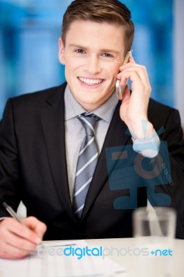 Smiling Corporate Guy Attending Phone Call Stock Photo