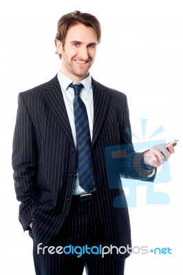 Smiling Corporate Head Holding Out Cellphone Stock Photo