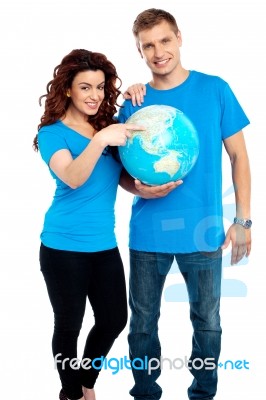 Smiling Couple Standing With Globe Stock Photo