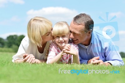 Smiling Couple With Daughter Posing At Outdoors Stock Photo