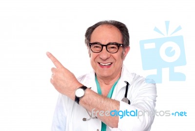 Smiling Doctor Pointing Upwards Stock Photo