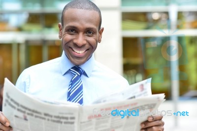 Smiling Executive Holding Newspaper Stock Photo