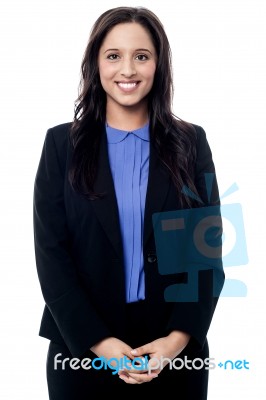 Smiling Executive Standing With Her Hands Clasped Stock Photo