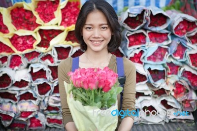 Smiling Face Of Younger Asian Woman With Pink Roses Flower Bouquet In Hand Stock Photo