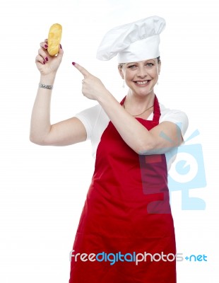 Smiling Female Cook Pointing Bread Stock Photo