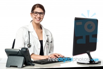 Smiling Female Doctor Working On Computer Stock Photo