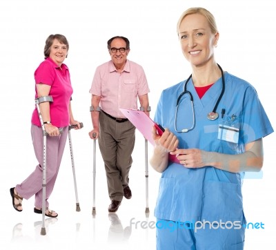 Smiling Female Physician With Aged Patients Stock Photo