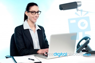 Smiling Female Secretary Working On Laptop Stock Photo