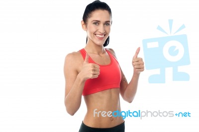 Smiling Fit Woman Gesturing Double Thumbs Up Stock Photo