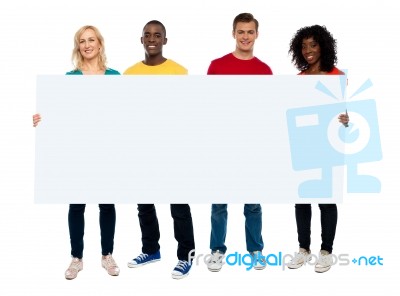 Smiling friends holding blank board Stock Photo