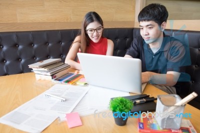 Smiling Friends Using Laptop In Cafe At The University Stock Photo