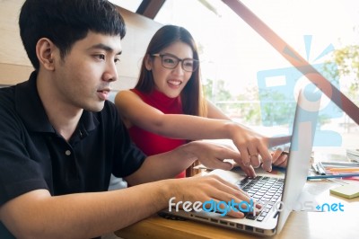 Smiling Friends With A Hot Drink Using Laptop In Cafe At The Uni… Stock Photo