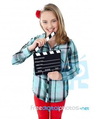 Smiling Girl Holding Clapperboard Stock Photo