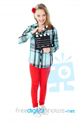 Smiling Girl Holding Clapperboard Stock Photo