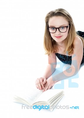 Smiling Girl Lying With Opened Book Stock Photo