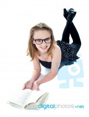 Smiling Girl Lying With Opened Book Stock Photo