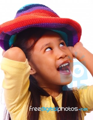 Smiling Girl Putting On Hat Stock Photo