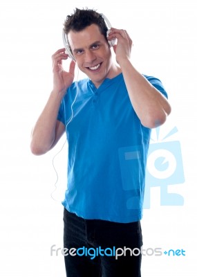 Smiling Guy Holding Headphones Stock Photo