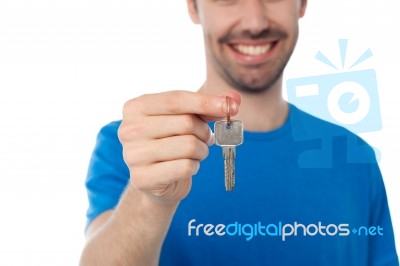 Smiling Guy Offering House Key Stock Photo