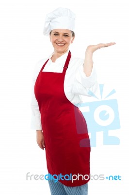 Smiling Lady Chef Showing Open Palm Stock Photo