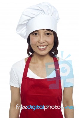 Smiling Lady Chef Wearing Red Apron Stock Photo