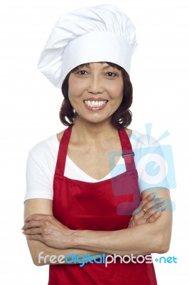 Smiling Lady Chef With Arms Crossed Stock Photo