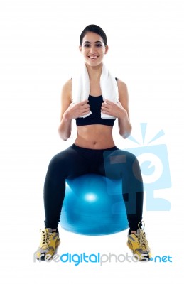 Smiling Lady Sitting On Blue Ball Stock Photo