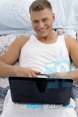 Smiling Laying Male Holding Laptop Stock Photo