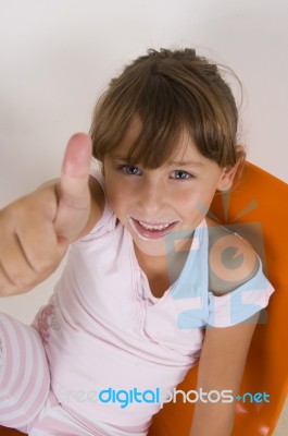 Smiling Little Girl Showing Thumb's Up Hand Gesture Stock Photo