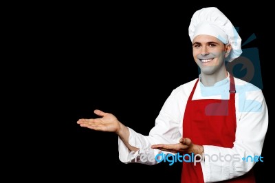 Smiling Male Chef Presenting Something Stock Photo