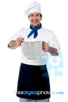 Smiling Male Cook Holding A Saucepan And Ladle Stock Photo