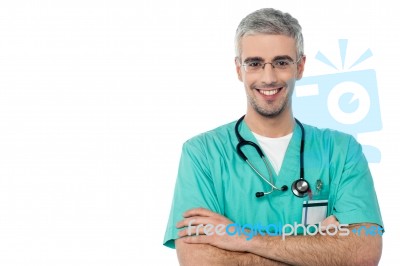 Smiling Male Doctor With Arms Crossed Stock Photo