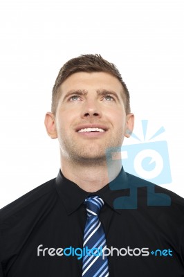 Smiling Male Executive Looking Upwards Stock Photo