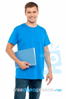 Smiling Man Holding Spiral Notebook Stock Photo