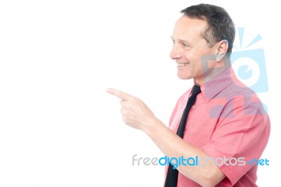 Smiling Man Pointing His Finger Towards Something Stock Photo