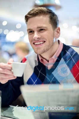 Smiling Man Reading Newspaper At Restaurant Stock Photo