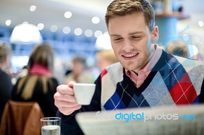 Smiling Man Reading Newspaper At Restaurant Stock Photo