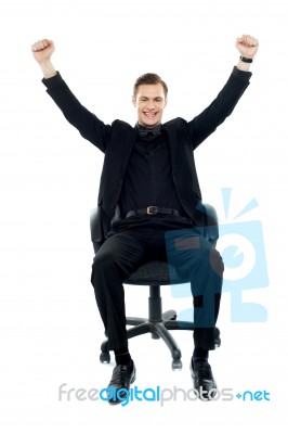 Smiling Man Sitting And Arms Raised Stock Photo