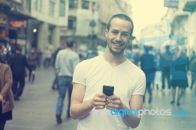 Smiling Man With Cell Phone Walking Stock Photo