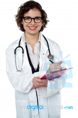 Smiling Medical Practitioner Writing Report Stock Photo