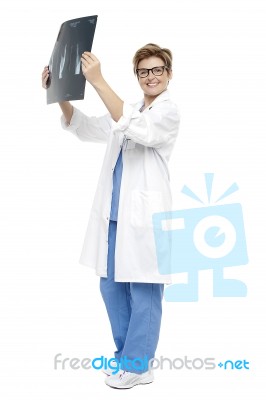 Smiling Middle Aged Doctor Holding Up X-ray Sheet Stock Photo