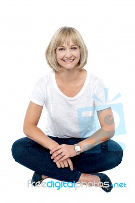 Smiling Middle Aged Woman Sitting On The Floor Stock Photo