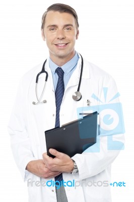 Smiling Professional Physician Carrying Clipboard Stock Photo