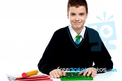 Smiling Schoolboy Using Calculator Stock Photo