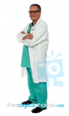 Smiling Senior Doctor Arms Crossed Stock Photo