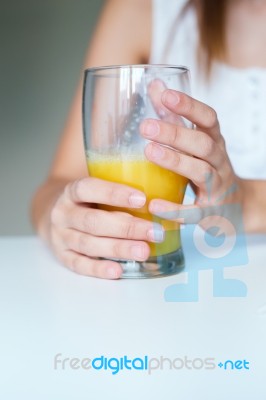 Smiling Woman Drinking Orange Juice At Home Stock Photo