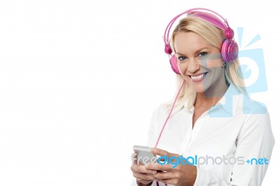 Smiling Woman Enjoying Music With Her Mobile Phone Stock Photo